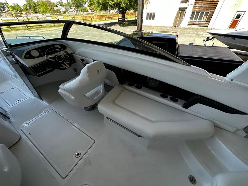 Slide: The Image of 2023 Four Winns HD8 OB boat interior with white seating and modern dashboard. - 18