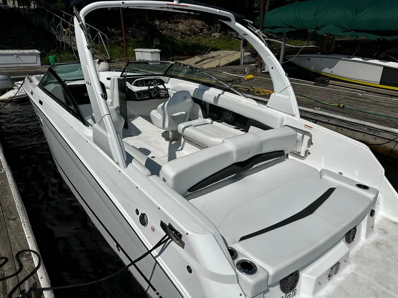 Slide: The Image of 2023 Four Winns HD8 OB boat docked, showcasing spacious seating and sleek design. - 28