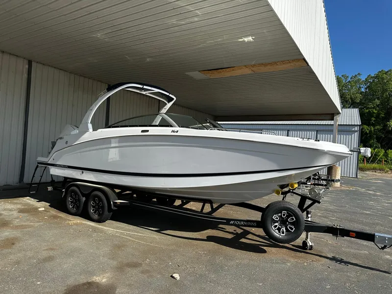 Slide: The Image of 2023 Four Winns HD8 OB boat on a trailer under a metal canopy. - 4