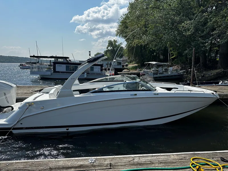 Slide: The Image of 2023 Four Winns HD8 OB boat docked at a marina on a sunny day. - 5