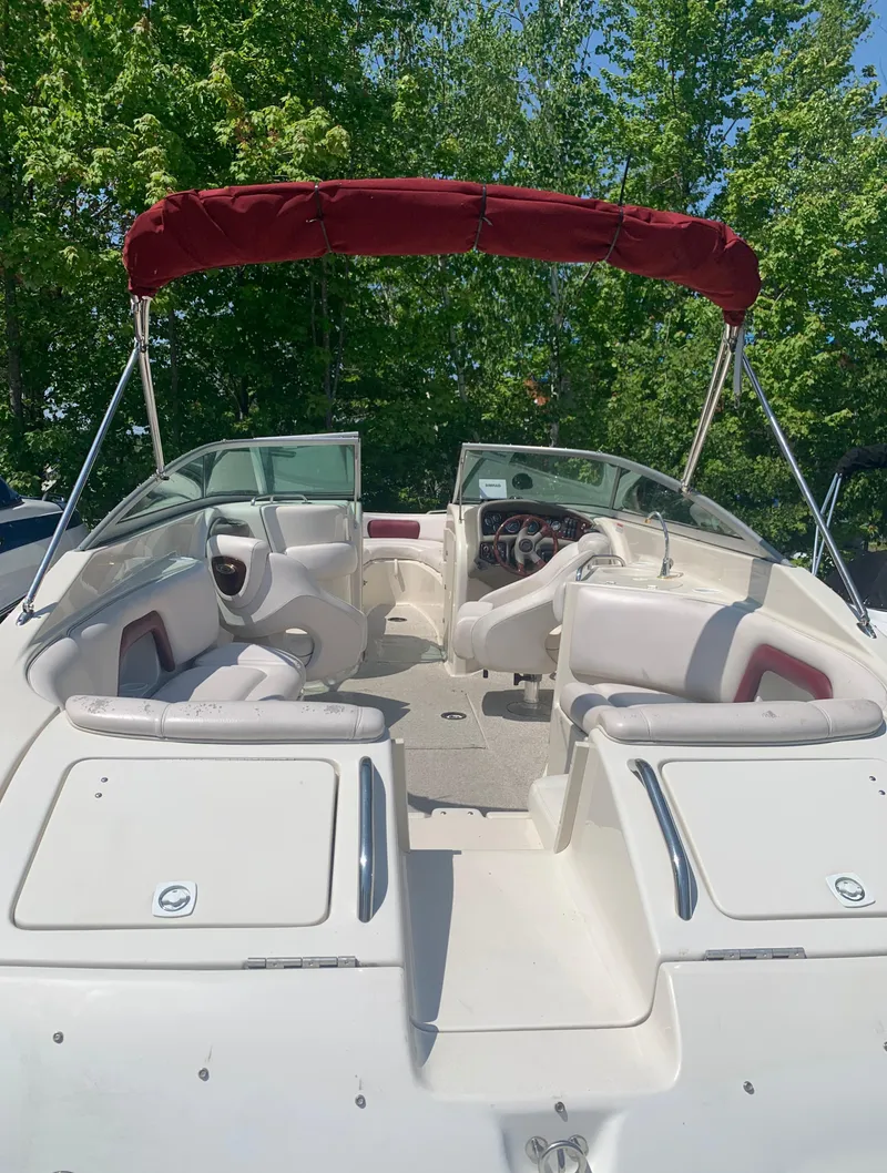 Slide: The Image of 2004 Crownline 270 BR boat with red canopy and white seating. - 10