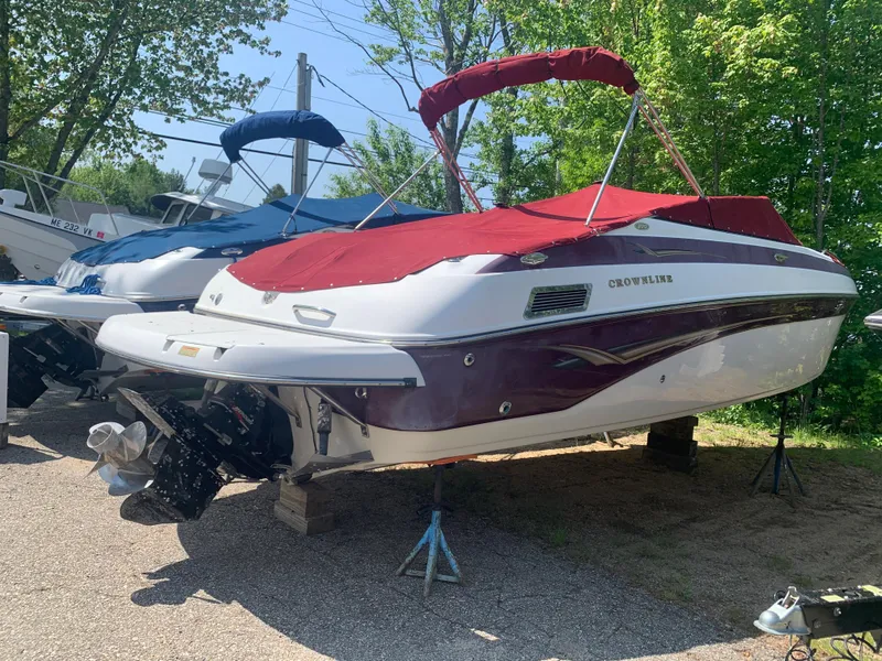Slide: The Image of 2004 Crownline 270 BR boat with red cover on dry dock. - 2