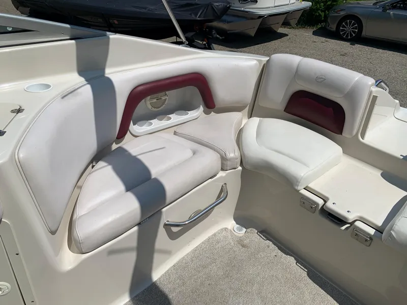 Slide: The Image of 2004 Crownline 270 BR boat interior seating area with white and maroon upholstery. - 24