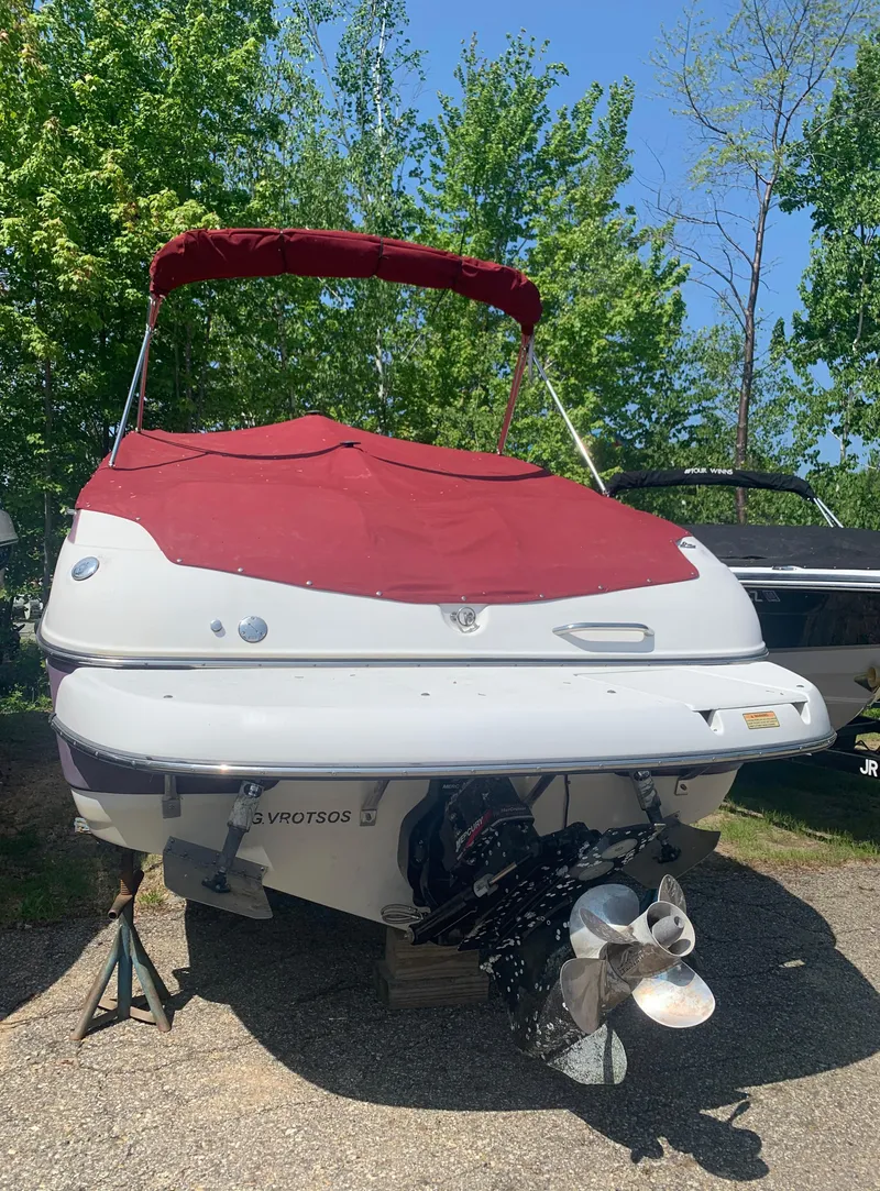 Slide: The Image of 2004 Crownline 270 BR boat with red cover, parked on a trailer. - 3