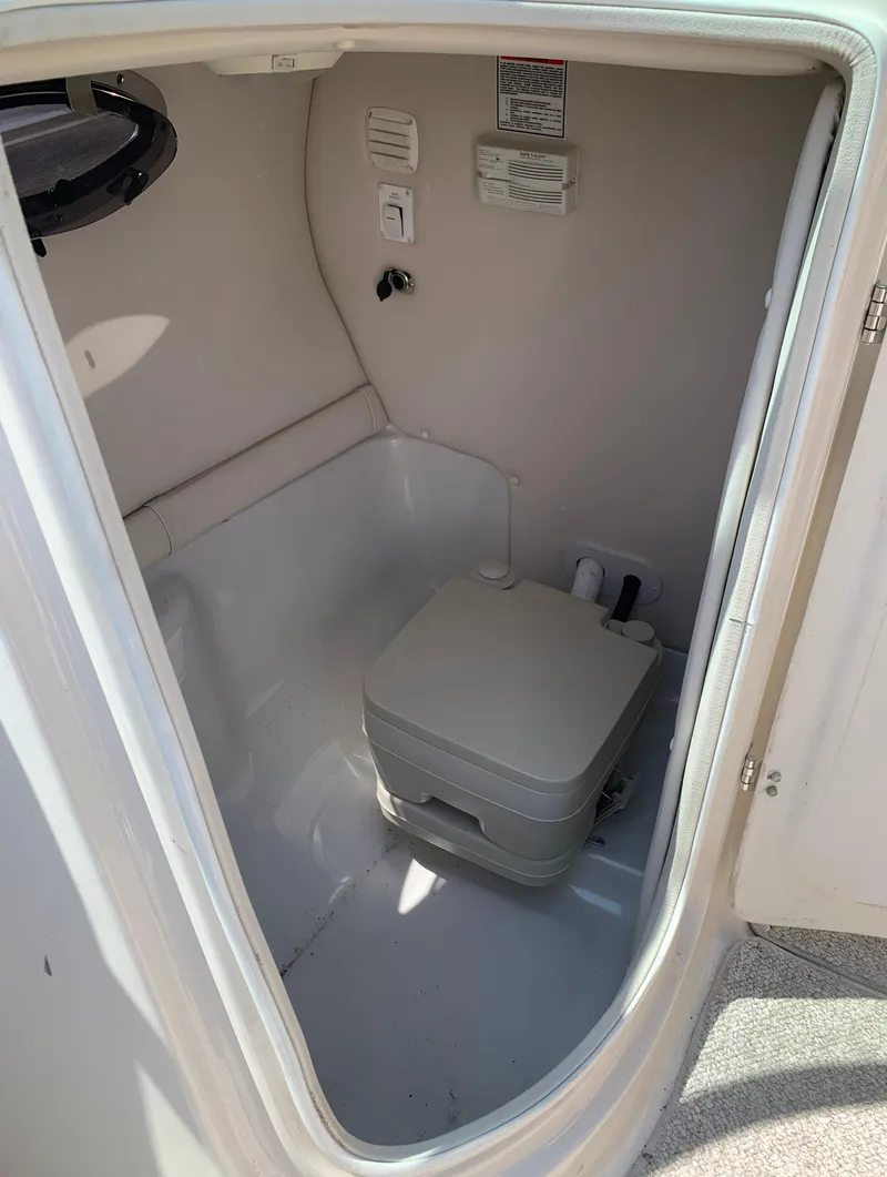 Slide: The Image of 2004 Crownline 270 BR boat interior bathroom with portable toilet. - 40