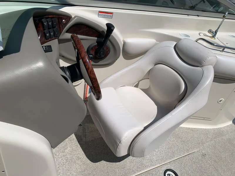 Slide: The Image of 2004 Crownline 270 BR boat cockpit with steering wheel and captain's chair. - 44