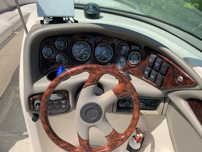 Slide: The Image of 2004 Crownline 270 BR boat dashboard with woodgrain steering wheel and instrument panel. - 46