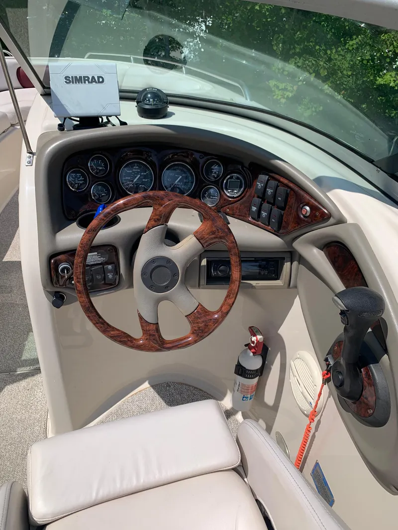 Slide: The Image of 2004 Crownline 270 BR boat dashboard with steering wheel and Simrad navigation system. - 47