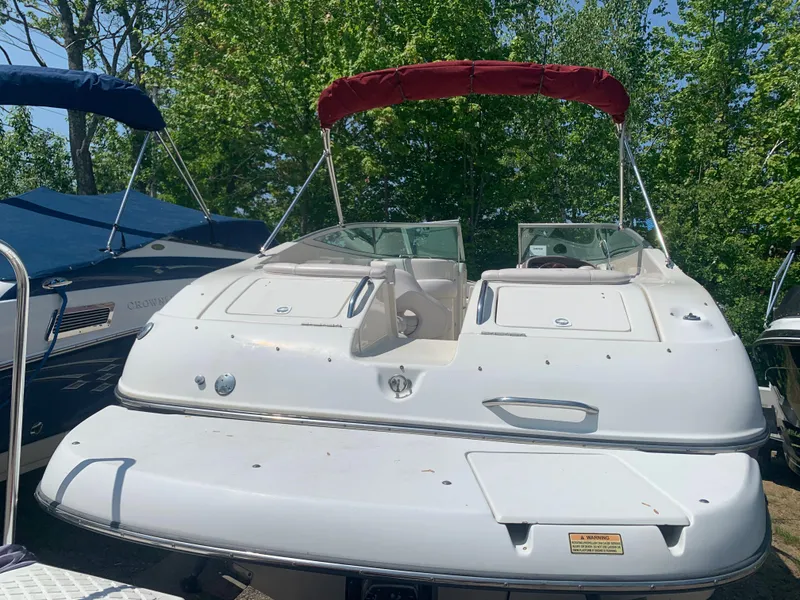 Slide: The Image of 2004 Crownline 270 BR boat with red canopy, docked outdoors. - 6