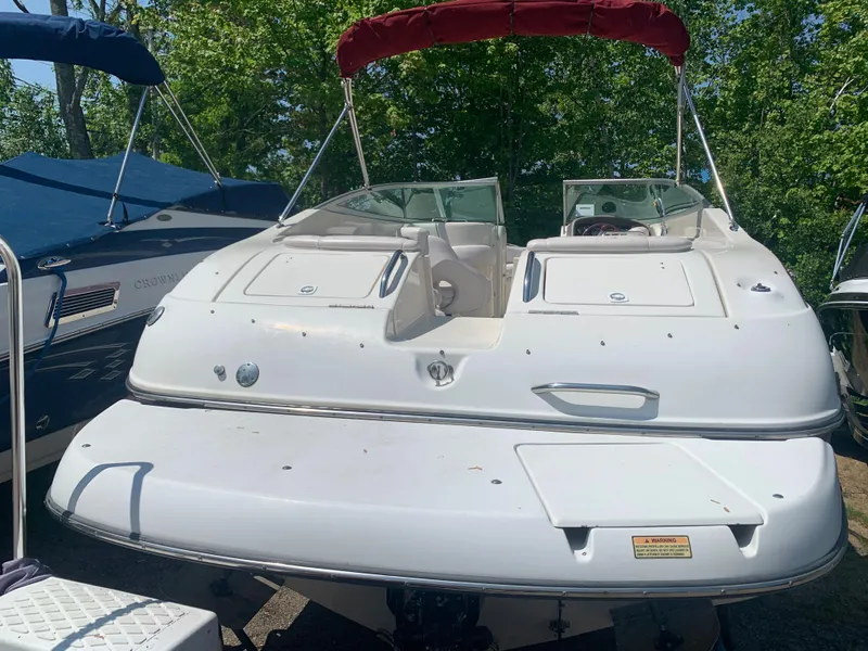 Slide: The Image of 2004 Crownline 270 BR boat with red canopy, docked outdoors. - 7