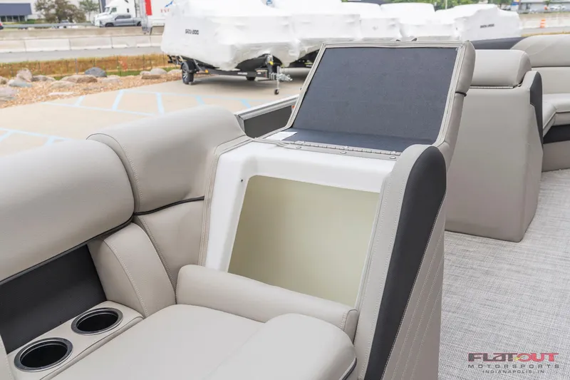 Slide: The Image of 2023 South Bay L-Lounge Tri-Toon 150HP boat interior with storage compartment and cup holders. - 12