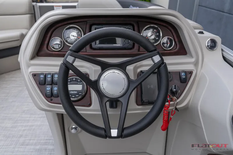 Slide: The Image of 2023 South Bay L-Lounge Tri-Toon 150HP boat dashboard with steering wheel and control panel. - 19