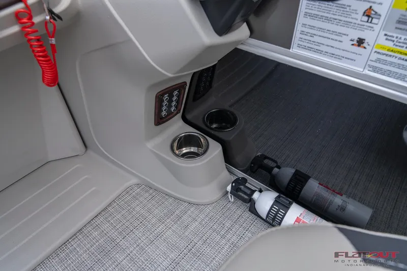 Slide: The Image of 2023 South Bay L-Lounge Tri-Toon 150HP boat interior with cup holders and fire extinguishers. - 23