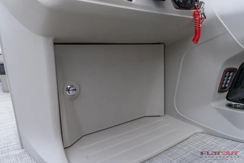 Slide: The Image of 2023 South Bay L-Lounge Tri-Toon 150HP storage compartment and control panel. - 24