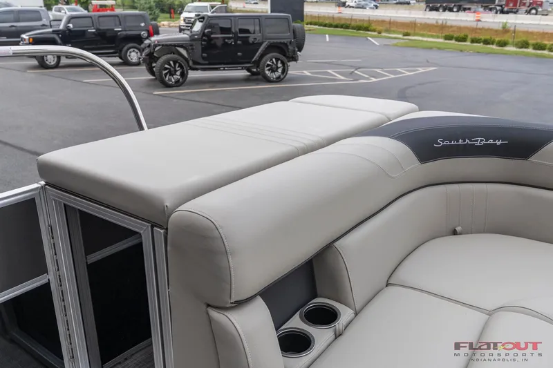 Slide: The Image of 2023 South Bay L-Lounge Tri-Toon 150HP boat with luxurious seating and cup holders. - 5
