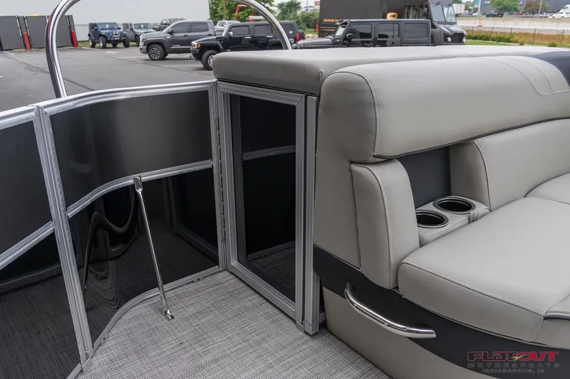 Slide: The Image of 2023 South Bay L-Lounge Tri-Toon 150HP, gray interior with cup holders and gate. - 6