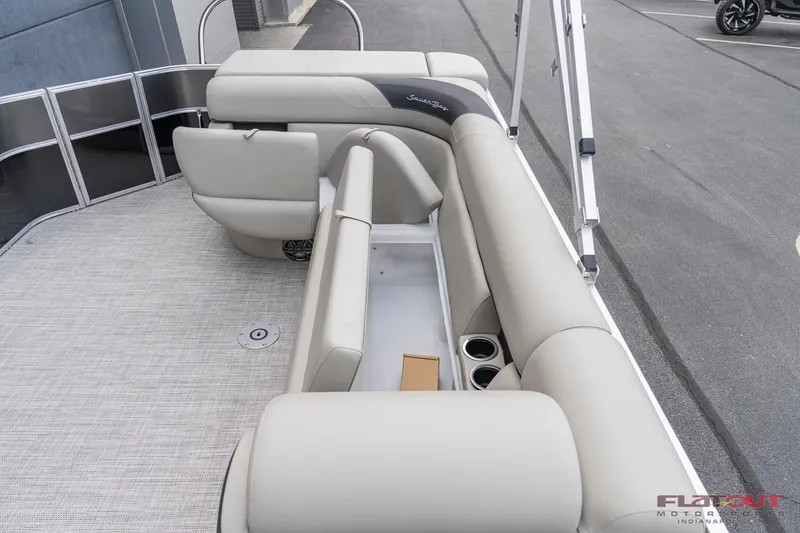 Slide: The Image of 2023 South Bay L-Lounge Tri-Toon 150HP boat interior with beige seating and cup holders. - 9