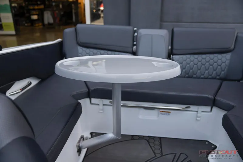 Slide: The Image of 2023 Scarab 215 ID boat interior with round table and cushioned seating. - 18