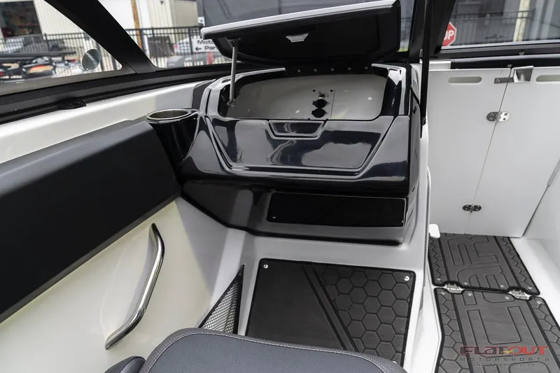 Slide: The Image of 2023 Scarab 215 ID boat interior with open storage compartment and black hexagonal floor mats. - 30