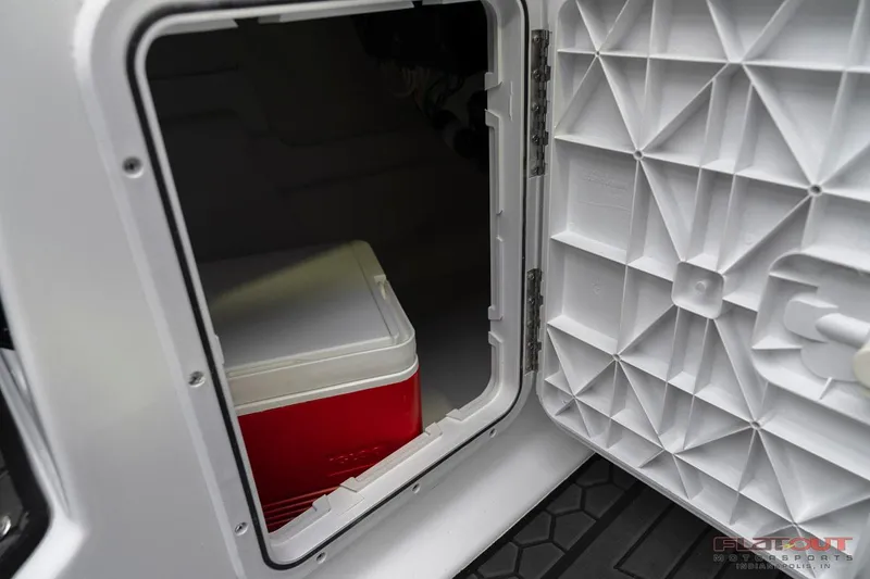 Slide: The Image of Storage compartment of 2023 Scarab 215 ID boat with a red cooler inside. - 40