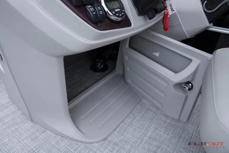 Slide: The Image of 2023 South Bay 224RSLE275 boat interior storage compartment and control panel. - 21