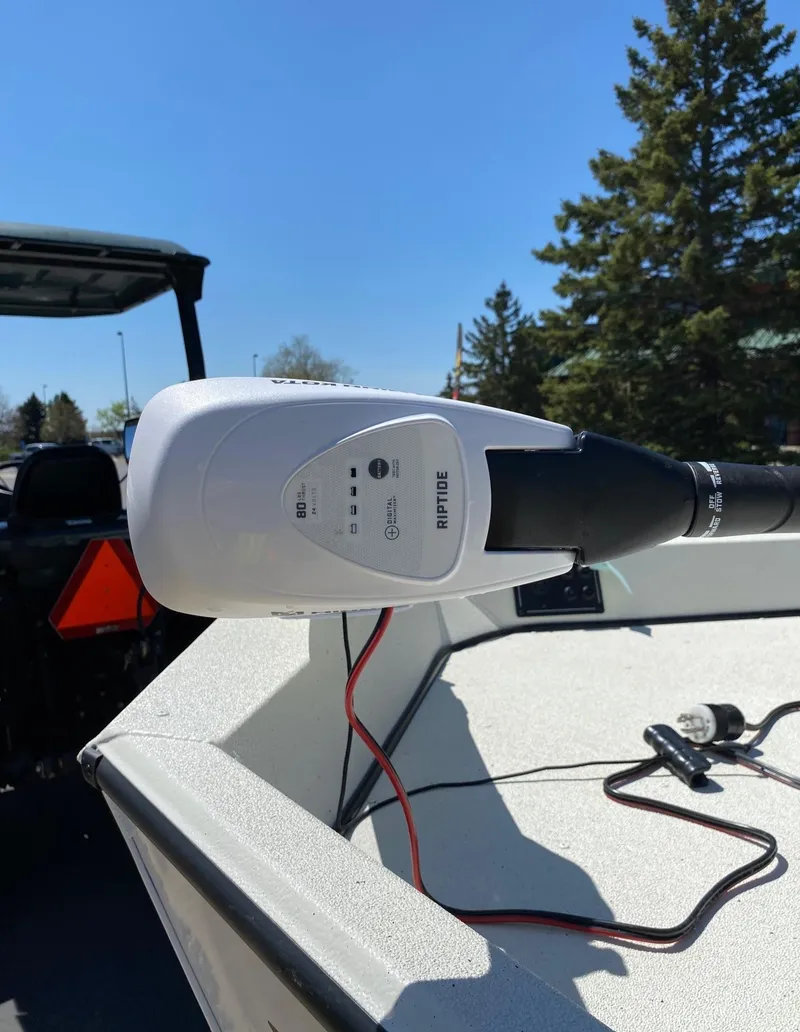 Slide: The Image of 2023 Ranger RB190 boat with mounted trolling motor, outdoors under clear blue sky. - 6
