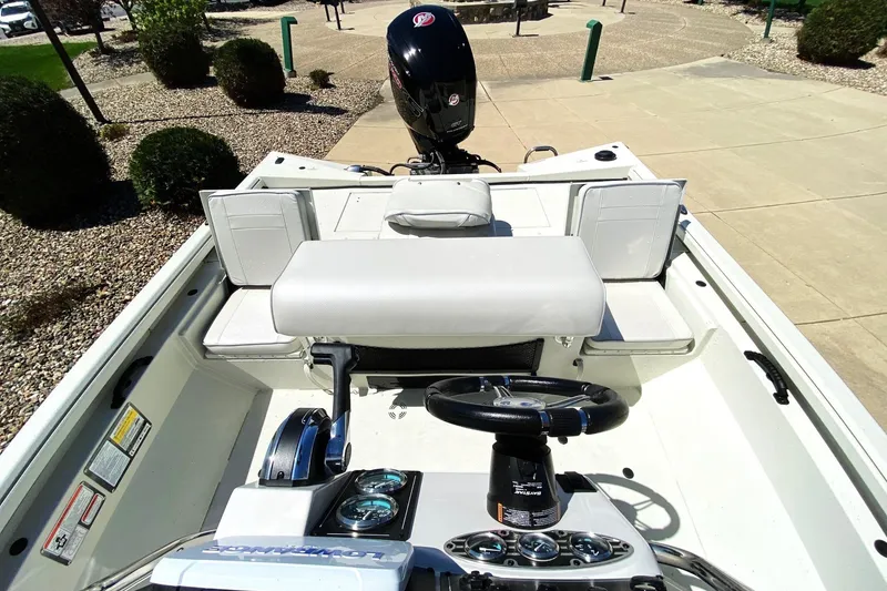Slide: The Image of 2023 Ranger RB190 boat interior with steering wheel and seating, parked on a paved area. - 7