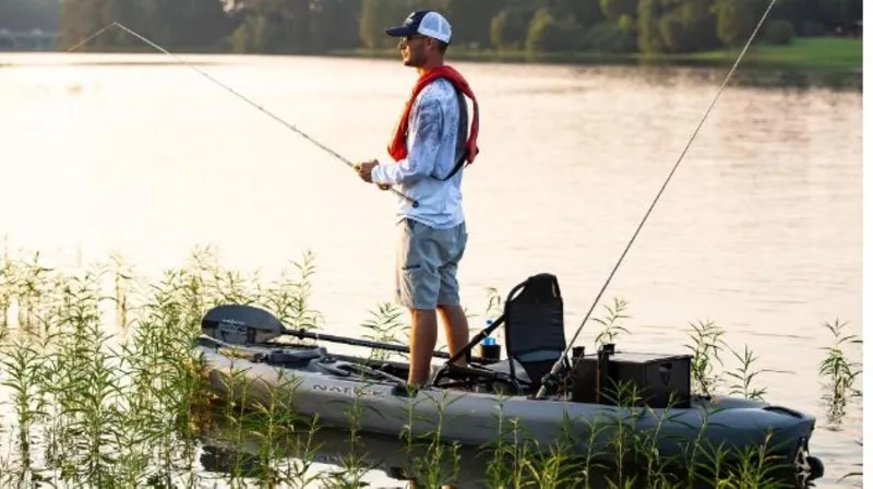 Slide: The Image of Man fishing on a 2023 Native Watercraft Falcon 11 kayak in a serene lake. - 10