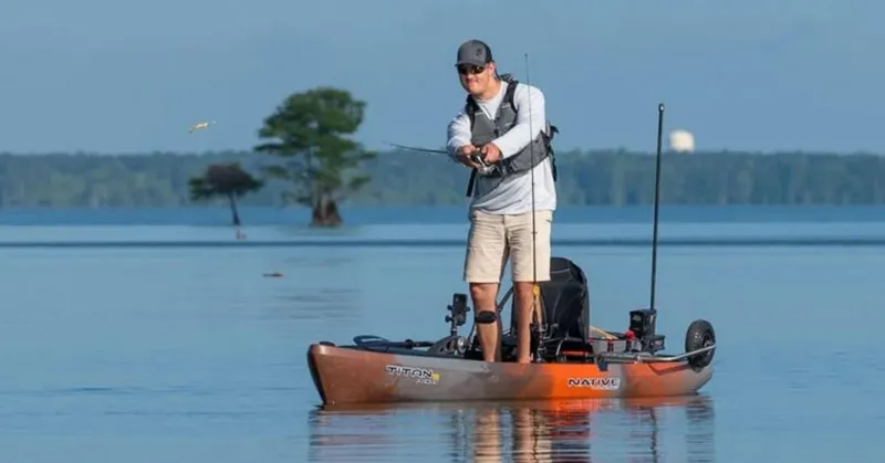 Slide: The Image of Man fishing on a 2023 Native Watercraft Titan Propel 12 kayak in a serene lake. - 10