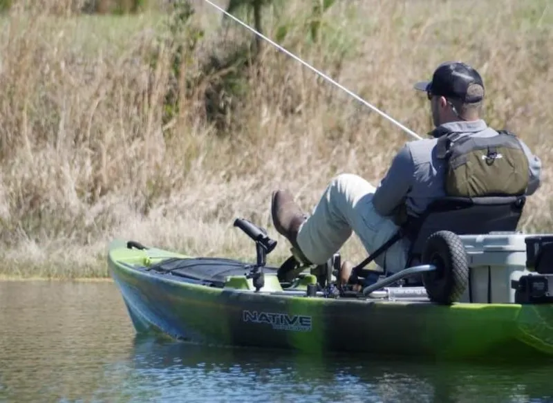 Slide: The Image of Man fishing from a 2023 Native Watercraft Titan Propel 13.5 kayak. - 0