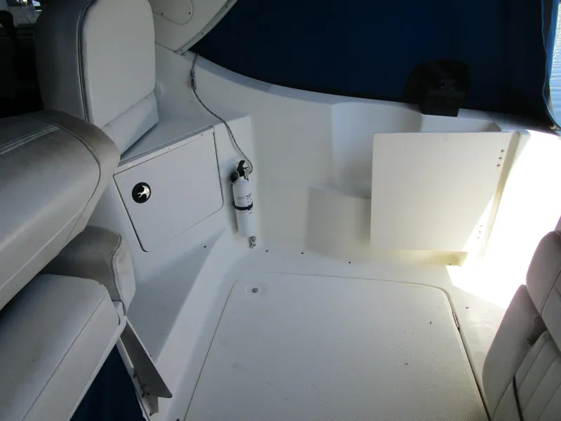 Slide: The Image of 2005 Bayliner 285 boat interior with white seating and storage compartment. - 14