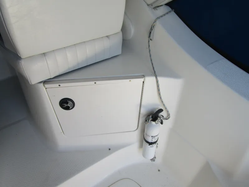 Slide: The Image of 2005 Bayliner 285 boat interior with white seating and fire extinguisher. - 18