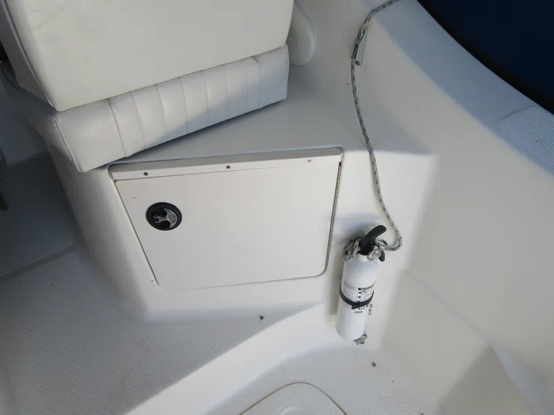Slide: The Image of 2005 Bayliner 285 boat interior with white seating and fire extinguisher. - 19