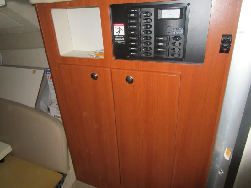 Slide: The Image of 2005 Bayliner 285 interior panel with control switches and storage cabinet. - 29
