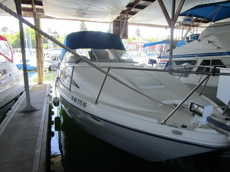 Slide: The Image of 2005 Bayliner 285 boat docked in a marina under a covered shelter. - 3