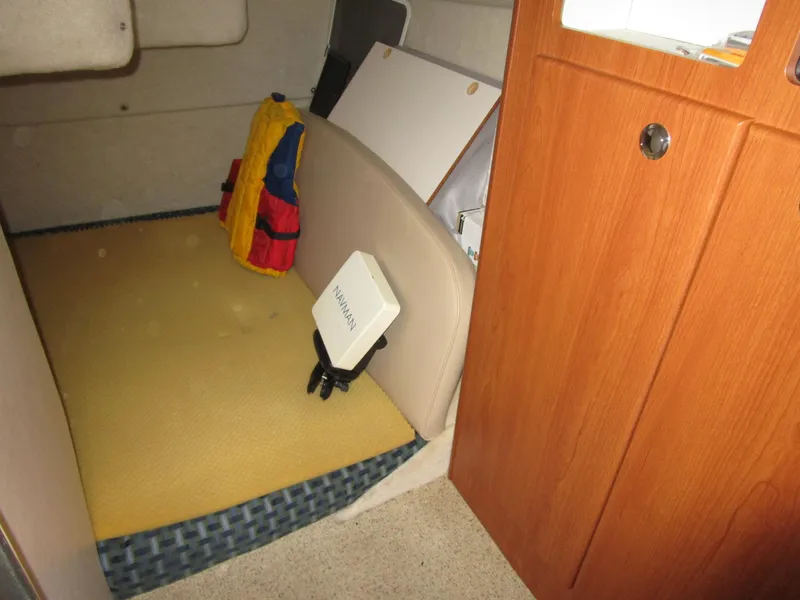 Slide: The Image of 2005 Bayliner 285 cabin interior with storage, life jackets, and wooden door. - 32