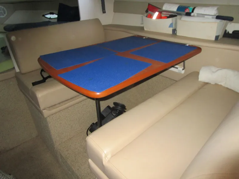 Slide: The Image of Interior of 2005 Bayliner 285 boat with beige seating and a wooden table. - 36