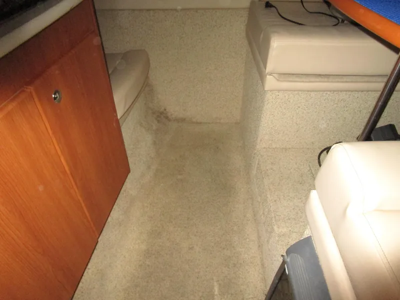 Slide: The Image of Interior of a 2005 Bayliner 285 boat, featuring seating and wooden cabinetry. - 40