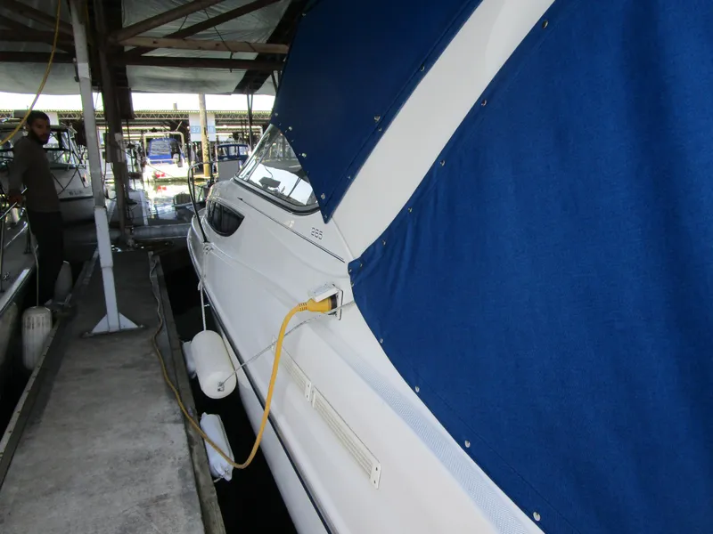 Slide: The Image of 2005 Bayliner 285 boat docked with blue cover and yellow power cable. - 5