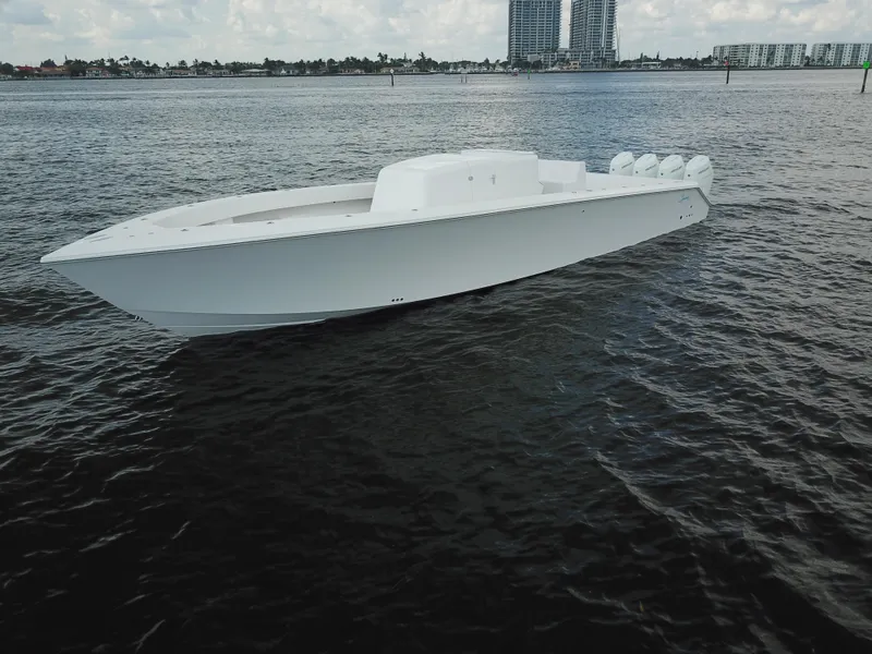 Slide: The Image of Sleek white Sparks 46 boat from 2025 on calm water with city skyline backdrop. - 0