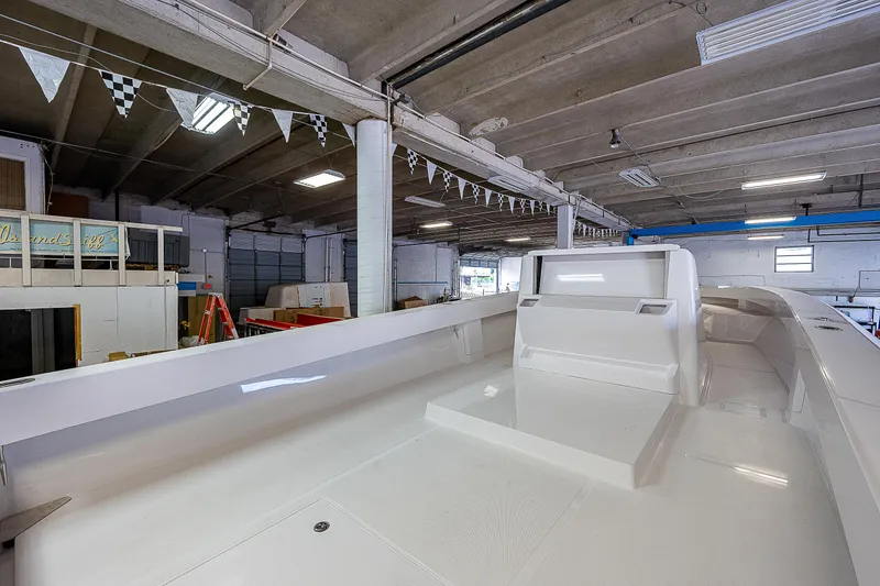 Slide: The Image of 2023 Sparks 46 boat in a workshop with an American flag. - 13