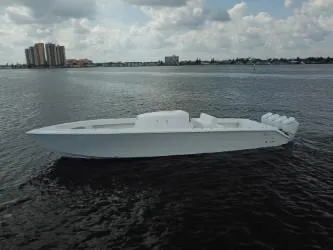 Slide: The Image of Sleek 2025 Sparks 46 boat on calm water under cloudy sky. - 2