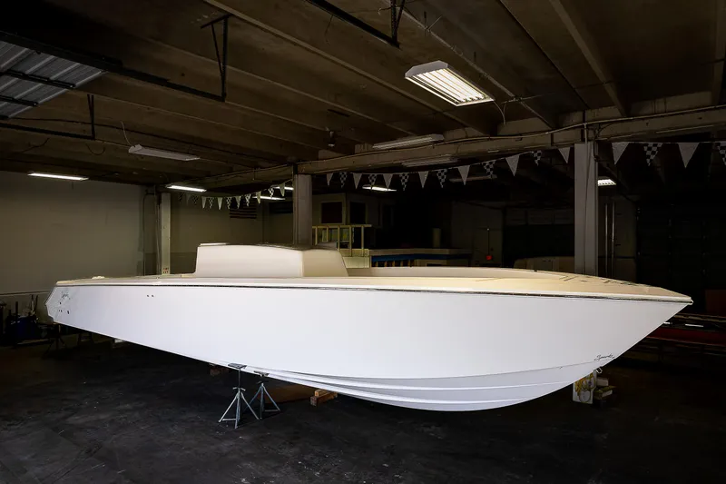 Slide: The Image of 2023 Sparks 46 boat interior in a warehouse, showcasing spacious deck and storage compartments. - 22