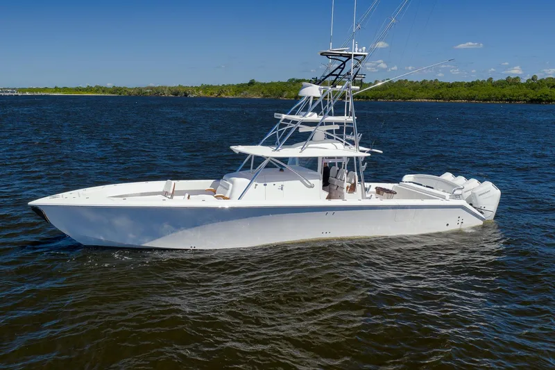 Slide: The Image of 2023 Sparks 46 boat cruising on clear blue water near a city skyline. - 37