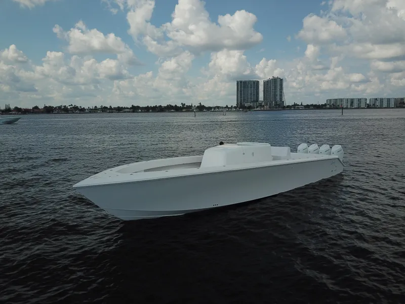 Slide: The Image of Sleek 2025 Sparks 46 boat on calm water with cloudy sky backdrop. - 6