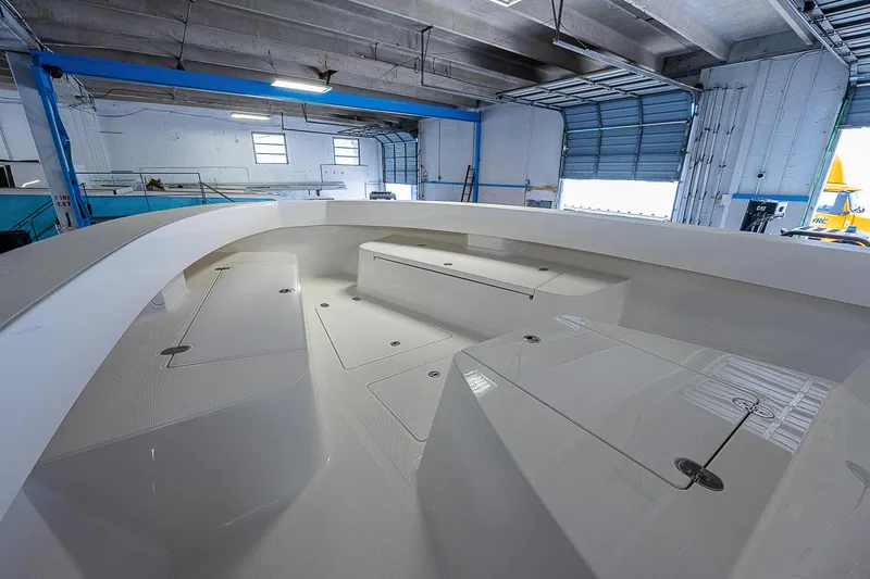 Slide: The Image of 2023 Sparks 46 boat interior in a warehouse, showcasing spacious deck and storage compartments. - 76