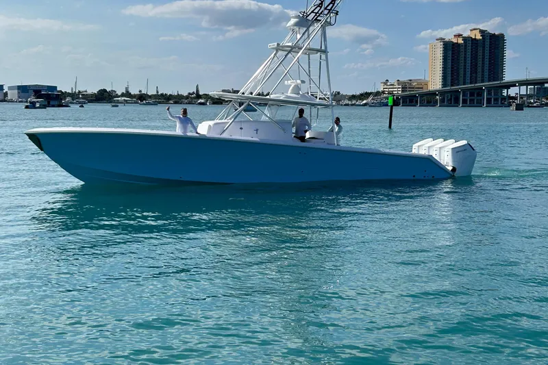 Slide: The Image of 2023 Sparks 46 boat cruising on clear blue water near a city skyline. - 91