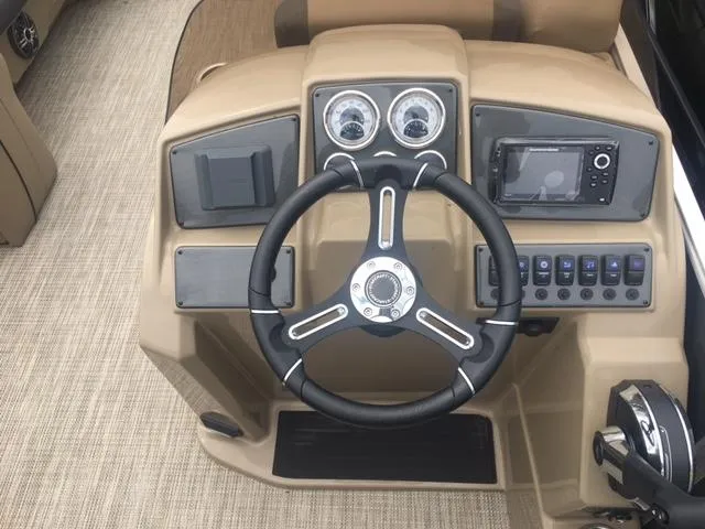 Slide: The Image of 2023 Starcraft EX 24 Q boat dashboard with steering wheel and control panel. - 4