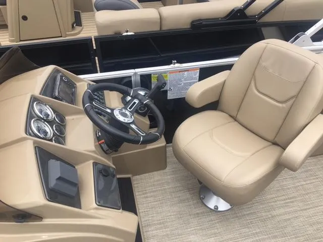Slide: The Image of 2023 Starcraft EX 24 Q boat helm with beige captain's chair and control panel. - 5