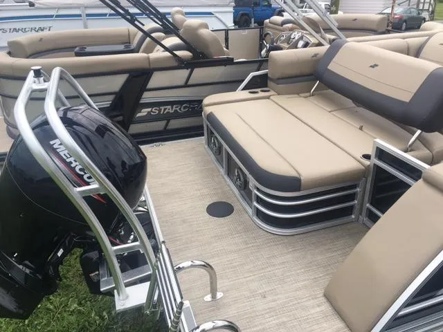 Slide: The Image of 2023 Starcraft EX 24 Q pontoon boat with Mercury outboard motor, beige seating, and spacious deck. - 6